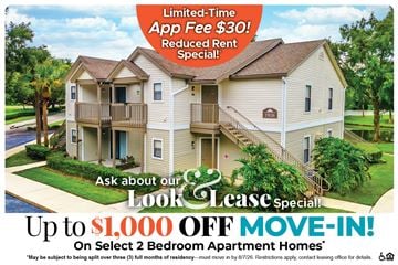Winter Garden apartment for rent - A large two-story apartment building with a lawn in front and a sign offering a limited-time app fee reduction and a move-in special.
