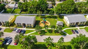 Orlando apartment for rent - a birdseye view of a playground in the middle of a yard between two buildings