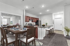 Orange City apartment for rent - dining area with table and chairs and a kitchen with barstools and dark cabinets