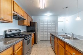 Sarasota apartment for rent - A kitchen with wooden cabinets and a black stove top oven.