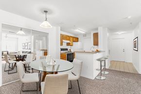 Sarasota apartment for rent - a dining area with a glass table and chairs and a kitchen in the background