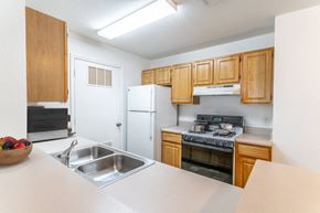 Orlando apartment for rent - a kitchen with wooden cabinets and white appliances