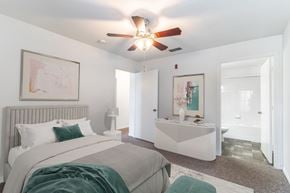 Melbourne apartment for rent - A bedroom with a bed, a bench, and a ceiling fan.