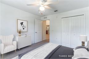 Orlando apartment for rent - A bedroom with a bed, a chair, a couch, and a painting on the wall.