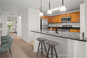 Orlando apartment for rent - A kitchen with a black counter top and two bar stools.