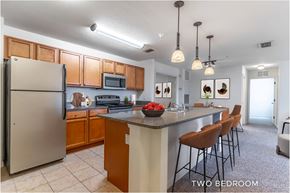 Fern Park apartment for rent - A kitchen with a refrigerator, microwave, and a counter with chairs.