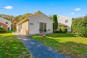 South Dartmouth apartment for rent - A house numbered 123 is surrounded by a grassy area with fallen leaves.