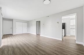 New Bedford apartment for rent - A spacious room with wooden flooring and white walls.