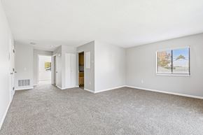 South Dartmouth apartment for rent - A spacious room with a carpeted floor and a window with blinds.
