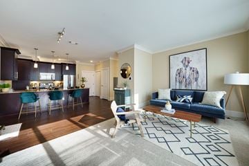Hudson apartment for rent - a living room and kitchen with a blue couch and a table