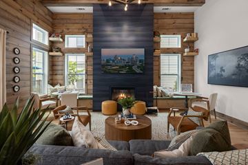Charlotte apartment for rent - A living room with a fireplace and a painting of a cityscape on the wall.