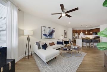 Raleigh apartment for rent - A living room with a white couch and a ceiling fan.