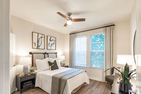 Raleigh apartment for rent - A bedroom with a bed, nightstand, and a ceiling fan.