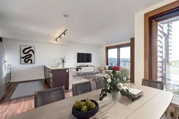 Seattle apartment for rent - a living room and dining room with a table and a television