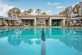 Rancho Cucamonga apartment for rent - Rancho Cucamonga, CA Apartments - Camino Real - Resort Style Swimming Pool With Lane Line, Lounge Chairs, Sun Umbrellas, And Clubhouse Patio Framed By Palm Trees.