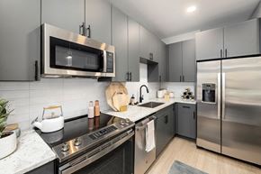 Raleigh apartment for rent - a modern kitchen with stainless steel appliances and black counter tops