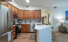 Scottsdale apartment for rent - Pet-Friendly Apartments in North Scottsdale, AZ - Desert Parks Vista - Kitchen Featuring Quartz Countertops, Wood Cabinetry, Tile Backsplash, and Stainless Steel Appliances in Open Living Area.