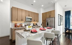 Fort Worth apartment for rent - Apartment Kitchen with Granite Island, Bar Stools, and Stainless Appliances