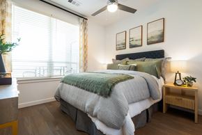 Centennial apartment for rent - A bedroom with a large bed and a ceiling fan.