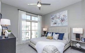 Alpharetta apartment for rent - Apartment Bedroom with Upholstered Bed, Large Window and Ceiling Fan