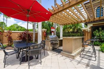 Outdoor kitchens with gas grills and shaded seating areas