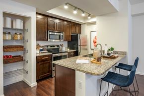Pembroke Pines apartment for rent - A kitchen with a granite countertop and a black chair.
