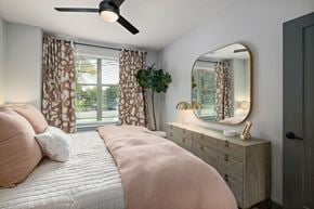 Raleigh apartment for rent - a bedroom with a bed and a mirror and a window