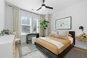 Charlotte apartment for rent - A bedroom with a bed, desk, chair, and a ceiling fan.