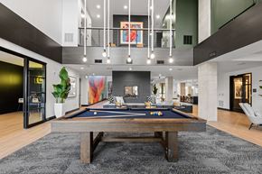 Charlotte apartment for rent - A pool table is in the middle of a room with a black carpet.