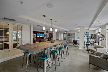 Resident lounge with billiards table, shuffleboard, card room, demonstration kitchen, and more