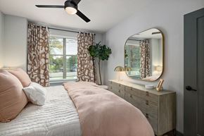 Raleigh apartment for rent - a bedroom with a bed and a mirror and a window
