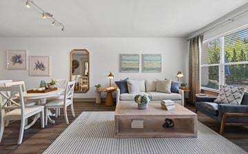 Swampscott apartment for rent - A living room with a white sofa, a coffee table, and a dining table with chairs.