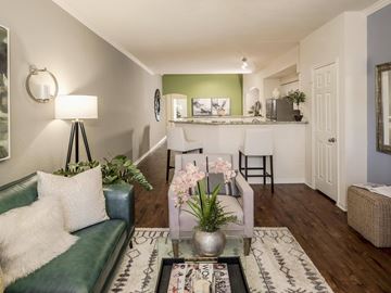 Saint Petersburg apartment for rent - A living room with a green couch and a coffee table with a vase of flowers on it.
