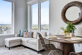 Revere apartment for rent - A dining room with a round table and chairs, a bench, and a view of the city through the windows.