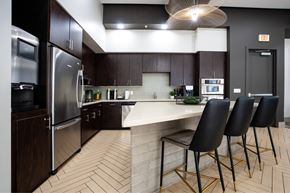 Phoenix apartment for rent - A kitchen with a white counter top and black chairs.