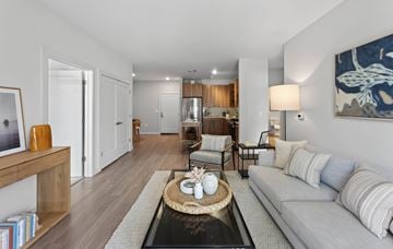 Marshfield townhouse for rent - A modern living room with a grey sofa, a coffee table, and a large painting on the wall.