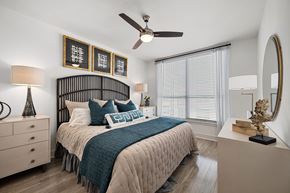 Walnut Creek apartment for rent - Serene bedroom with a statement headboard, ceiling fan, and oversized window for soft natural light