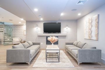 Stamford apartment for rent - A modern living room with a grey sofa set and a flat screen TV mounted on the wall.