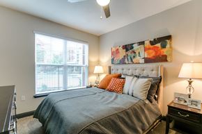 Houston apartment for rent - a bedroom with a bed and a large window