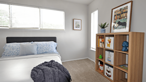 Plano apartment for rent - A bedroom with a white bed and a wooden bookshelf.