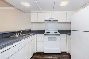 Plano apartment for rent - a kitchen with white cabinets and a stove and a sink