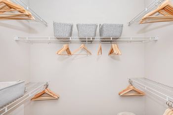 Walk in closet with shelves and clothes racks