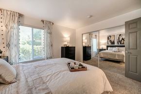 Sacramento apartment for rent - A bedroom with a large bed and a mirrored wall.