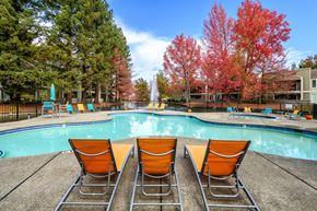 Sacramento apartment for rent - a swimming pool with orange chairs next to it