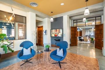 Sacramento apartment for rent - A living room with two blue chairs and a table in the middle.