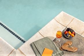 Ewing Township apartment for rent - A poolside setting with a towel, flip flops, and a bowl of fruit.
