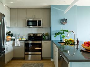Jersey City apartment for rent - a kitchen with stainless steel appliances and a clock on the wall