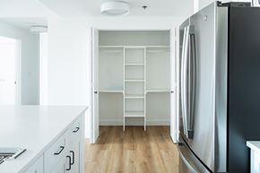Jersey City apartment for rent - a kitchen with white cabinets and a refrigerator and shelves