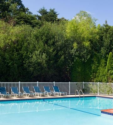 Jackson apartment for rent - a swimming pool with blue chairs next to a white fence
