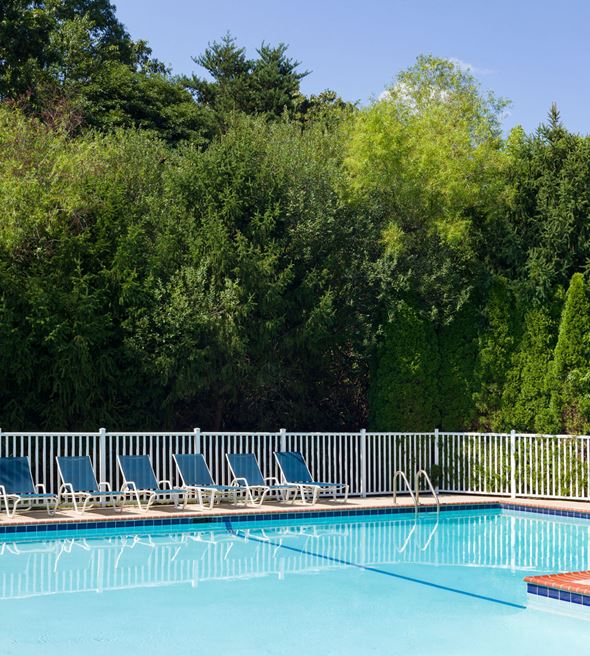 Jackson apartment for rent - a swimming pool with blue chairs next to a white fence